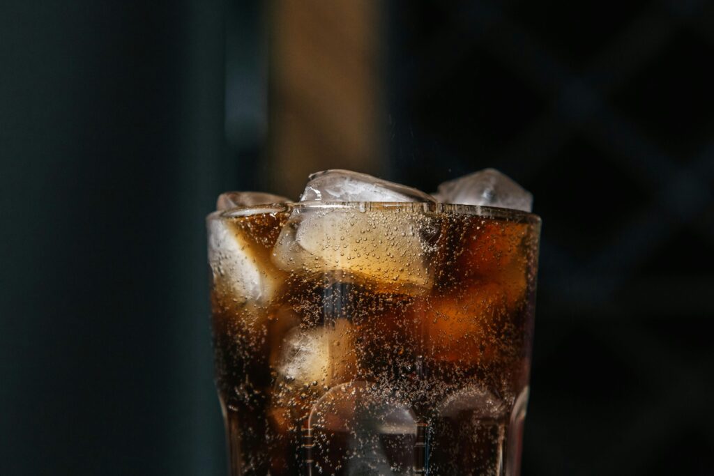 Cooling beverage with fizzy bubbles and ice cubes in a clear glass.